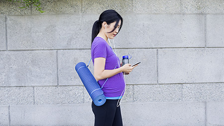 A young female with a yoga mat.