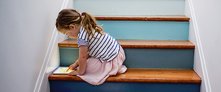 Girl tablet on staircase.